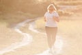 Happy active thick adult old lady woman in sunglasses and sneakers running outdoors in nature for weight loss with copy space Royalty Free Stock Photo