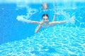 Happy active underwater child swims in pool, beautiful healthy girl swimming