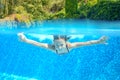 Happy active underwater child swims in pool