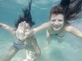 Happy active underwater girls swimming in sea and having fun on family summer vacation Royalty Free Stock Photo