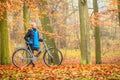 Happy active woman riding bike in autumn park. Royalty Free Stock Photo