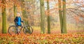 Happy active woman riding bike in autumn park. Royalty Free Stock Photo