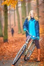 Happy active woman riding bike in autumn park. Royalty Free Stock Photo