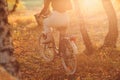 Happy active young woman riding vintage bicycle in autumn park at sunset Royalty Free Stock Photo