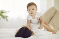 Happy adorable baby boy cuddling together with his mommy on comfortable bed at home Royalty Free Stock Photo