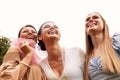 Happy adorable bride in a white dress with white veil and two bridesmaids in blue and beige dress with pink veils