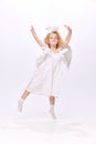 Happy, adorable, cute baby girl child in image f angel dancing and handing fun isolated over white studio background Royalty Free Stock Photo