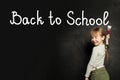 Happy adorable cute laughing child girl writing Back to school on blackboard background with copy space Royalty Free Stock Photo