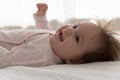 Happy adorable few month baby lying on white linen sheet Royalty Free Stock Photo