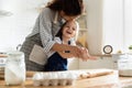 Happy adorable little child girl enjoying cooking with mother.