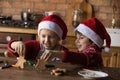 Happy adorable little children sibling playing with Christmas gingerbreads. Royalty Free Stock Photo