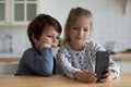 Happy adorable little kids playing cellphone at home. Royalty Free Stock Photo