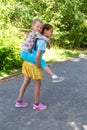 Happy adorable preschool girl on a piggy back ride with her elder sister Royalty Free Stock Photo