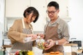 Happy adult Asian couples are cooking in the kitchen together, making a salad bowl Royalty Free Stock Photo
