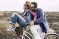 Happy adult caucasian, couple having fun with bicycle in outdoor leisure activity. concept of active playful people with bike