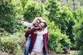 Happy adult couple enjoy the nature outdoor leisure activity together with man carrying cheerful beautiful woman with green forest Royalty Free Stock Photo