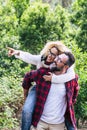 Happy adult couple enjoy the nature outdoor leisure activity together with man carrying cheerful beautiful woman with green forest Royalty Free Stock Photo