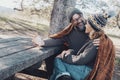 Happy adult couple enjoy time together in outdoor leisure activity sitting on a wooden bench and table at the park in holiday Royalty Free Stock Photo