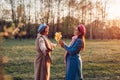 Adult daughter giving flowers as present to her senior mother in spring park. Mother`s day concept. Family values Royalty Free Stock Photo