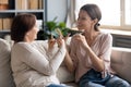 Happy adult daughter and older mother speaking sign language