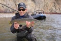 Happy adult fisherman holding steelhead trout Royalty Free Stock Photo