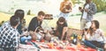 Happy adult friends having picnic bbq dinner outdoor - Young people eating and drinking wine in summer weekend day - Friendship,
