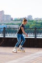 A girl rides roller skates in a city Park in summer