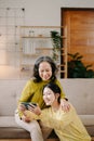 Happy adult granddaughter and senior grandmother having fun enjoying talk sit on sofa in living room at home Royalty Free Stock Photo