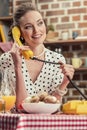 happy adult housewife talking by vintage wired phone Royalty Free Stock Photo