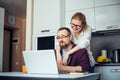 Happy adult loving family couple looking at laptop screen, sitting at table in kitchen. Bearded man showing funny video on Royalty Free Stock Photo