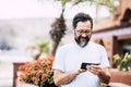 Happy adult man with beard and glasses use modern technology phone outoor and enjoy internet conneciton device