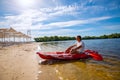 Happy adult man relaxing on a kayak next to the beach