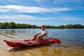 Happy adult man relaxing on a kayak next to the beach