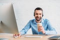 happy adult technical support professional working at office and drinking coffee from Royalty Free Stock Photo