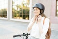 Happy adult woman fastening her helmet before a bike commute to her home Royalty Free Stock Photo