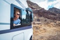 Happy adult woman smile and enjoy travel destination inside her camper van. Cheerful female people enjoy travel with camper van. Royalty Free Stock Photo