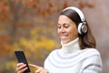 Happy adult woman using headphones and phone Royalty Free Stock Photo