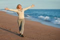 Happy adult woman on vacation walks by the sea. Royalty Free Stock Photo