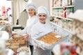 Happy adult women staff offering sweets