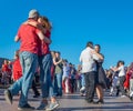 Happy adults are dancing tango or waltz on the city street