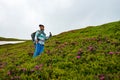 Happy adventurer female among flowering pink rhododendrons Royalty Free Stock Photo