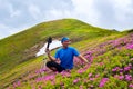 Happy adventurer relaxing among flowering rhododendrons Royalty Free Stock Photo