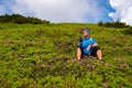 Happy adventurer relaxing on the green mountain slope Royalty Free Stock Photo