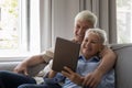 Happy affectionate middle aged family couple using digital tablet. Royalty Free Stock Photo