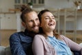 Happy affectionate young family couple watching TV programs.