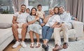 Happy and affectionate young mixed race family of seven sitting on a sofa in the home living room. Married couple with Royalty Free Stock Photo