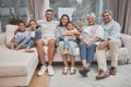 Happy and affectionate young mixed race family of seven sitting on a sofa in the home living room. Married couple with Royalty Free Stock Photo