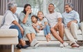 Happy and affectionate young mixed race family of six sitting on a sofa in the home living room. Married couple with Royalty Free Stock Photo