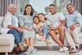 Happy and affectionate young mixed race family of six sitting on a sofa in the home living room. Married couple with Royalty Free Stock Photo