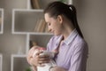 Happy affectionate young mother holding in hands sleeping baby. Royalty Free Stock Photo